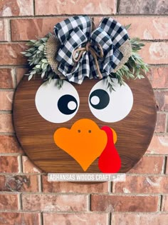 a wooden sign with a turkey on it's face and a bow around its head