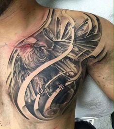 a man's chest with an eagle and snake tattoo on it