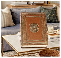 a book sitting on top of a table in front of a blue couch with pillows