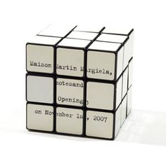 a white and black cube with words written on it's sides, sitting in front of a white background