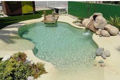 a small pool surrounded by rocks and plants