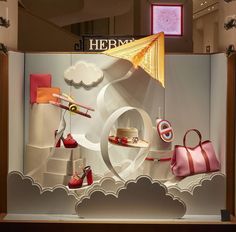 a display case with shoes and purses on it's sides, in the shape of clouds