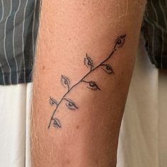 a man with a tattoo on his leg that has a small plant growing out of it