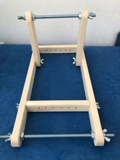 a wooden frame sitting on top of a blue carpet with two screws in it