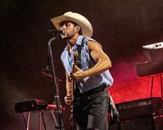 a man in a cowboy hat singing into a microphone