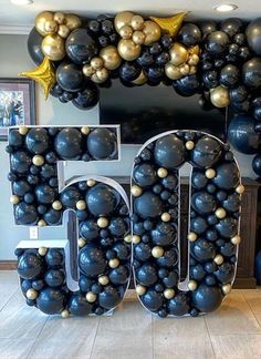 the number 50 is surrounded by balloons and stars in black, gold and silver colors