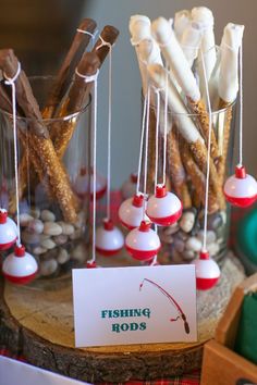 an image of fishing rods on display in a glass vase with rocks and sticks sticking out of it