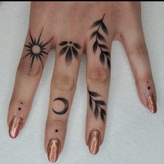 a woman's hand with tattoos on it and two fingers that have different designs