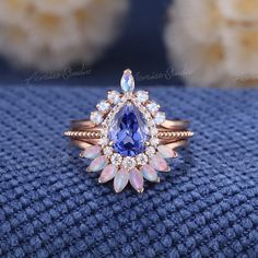 Vintage Pear Cut Conrnflower Sapphire Engagement Ring Set Rose Gold Moonstone Wedding Rings 3pcs Halo Ring Opal Bridal Set Anniversary Gifts Jewelry Information: ♡ Handmade, high-quality item ♡ Material: SOLID 14K/18K GOLD ( can be made in yellow/white/rose gold ) ♡ Center stone: Lab grown sapphire ♡ Size/Weight:  8x6mm ♡ Cut - Pear Shaped ♡ Color: Cornflower blue ♡ Side stones: Moissanite/ Natural diamonds ♡ Weight:  About 0.21ct ♡ Cut - Round Shaped ♡ Clarity - SI-VS ♡ Color- G-H ♡ Band Width: Around 1.6mm ♡ Top Wedding band  ♡ Stone: Moonstone ♡ Color- Blue ♡ Cut - Marquise & Round Shaped ♡ Band Width: Around 1.6mm ♡ Bottom Wedding Band ♡ Stone: Natural Australia Opal ♡ Color: White with fire ♡ Band Width: Around 1.6mm Visit my shop for more jewelry: https://www.etsy.com/shop/acraisejew Cornflower Sapphire Ring, Moonstone Wedding Ring, Opal And Sapphire Ring, Opal Wedding Band, Sapphire Engagement Ring Set, Opal Wedding, Ring Opal, Sapphire Engagement Ring Blue, Engagement Rings Opal