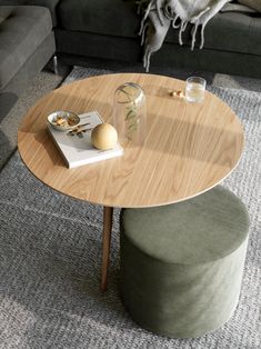 a living room with a couch, coffee table and stools in it's center