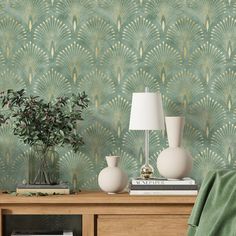 a table with two vases and a lamp on it next to a green wallpaper