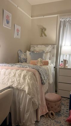 a white bed sitting next to a window in a bedroom on top of a rug