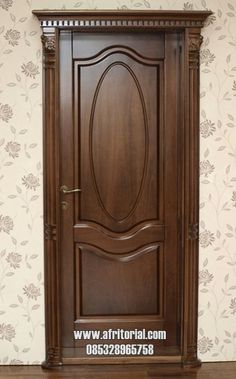 a wooden door in front of a floral wallpaper