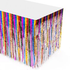 a white table topped with lots of colorful streamers on it's sides,