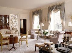 a living room filled with white furniture and lots of window curtains on the windowsill