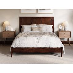 a bed with two nightstands next to each other in a white and brown bedroom