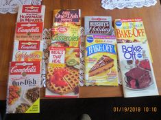 there are many magazines on the table with doily around them and one has a slice of cake