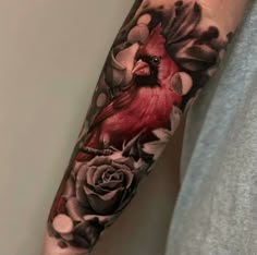 a man with a red bird and flowers on his arm