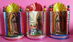 three colorful tin canisters with images of the virgin mary and jesus on them