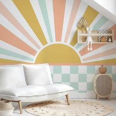 a white couch sitting on top of a rug next to a wall painted with sunbursts