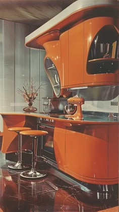 an orange kitchen with two stools and a center island