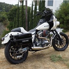 a police motorcycle parked on the side of a road in front of some trees and bushes