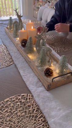 a tray with candles and christmas decorations on it