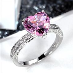 a pink heart shaped ring with diamond accents