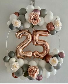 the number twenty five is surrounded by balloons and flowers in silver, pink, white and grey colors