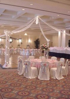 the banquet hall is decorated with white and pink linens, sashers, and lights