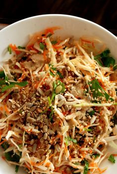 a white bowl filled with lots of veggies and sprouts on top of it