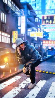 a man leaning over on the side of a road while talking on a cell phone