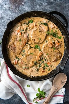 a skillet filled with chicken and sauce on top of a table