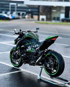 a green and black motorcycle parked in a parking lot