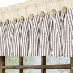 a curtain with buttons hanging on it's side next to a window sill