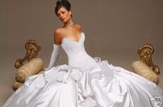 a woman in a white wedding dress sitting on a gold chair with her hands behind her back