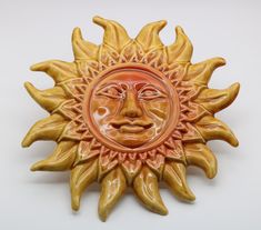 a ceramic sun face on a white background