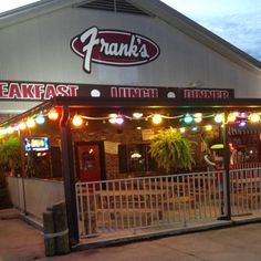 the entrance to frank's steak and dinner bar at night with lights on it