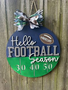 a football sign hanging on the side of a wooden fence