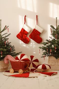 christmas stockings hanging on the wall with candy canes and other holiday decorations in front of them