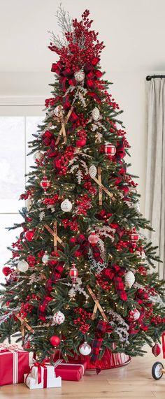 a decorated christmas tree with red and silver ornaments on the top is surrounded by presents