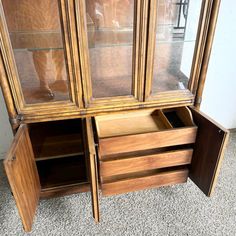 an antique china cabinet with glass doors and drawers