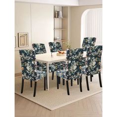 a dining room table and chairs with blue floral upholstered fabric on the back