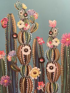 a painting of cactuses with flowers on them