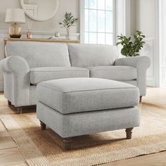 a living room scene with focus on the couch and footstool