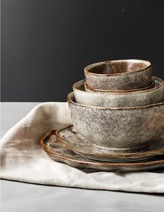 a stack of dishes sitting on top of a white cloth