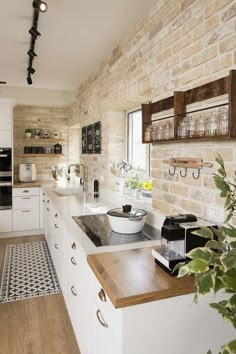 a kitchen with white cabinets and wooden counter tops