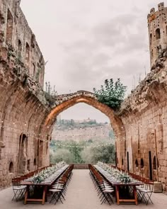 an outdoor dining area with tables and chairs set up in front of the archways