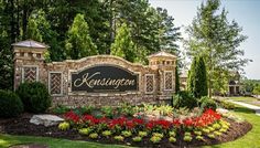 the entrance sign to kesnuton golf club, located in front of trees and flowers