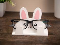 a white bunny wearing glasses on top of a wooden table